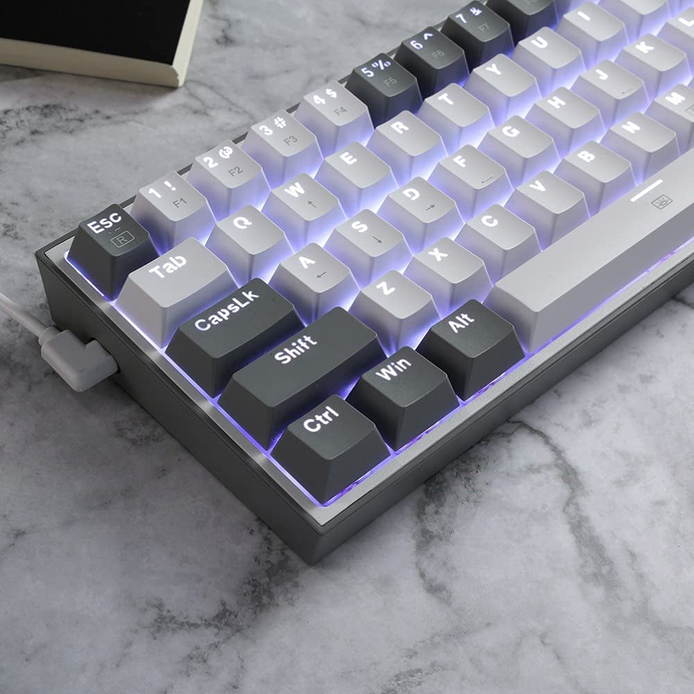 Close-up of a compact mechanical keyboard with white and dark gray keycaps and purple RGB backlighting on a marble surface