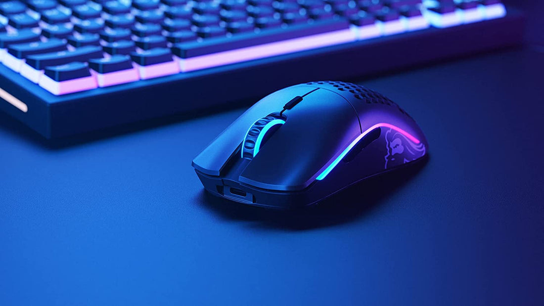 Glorious Model O wireless gaming mouse on a desk setup with RGB keyboard