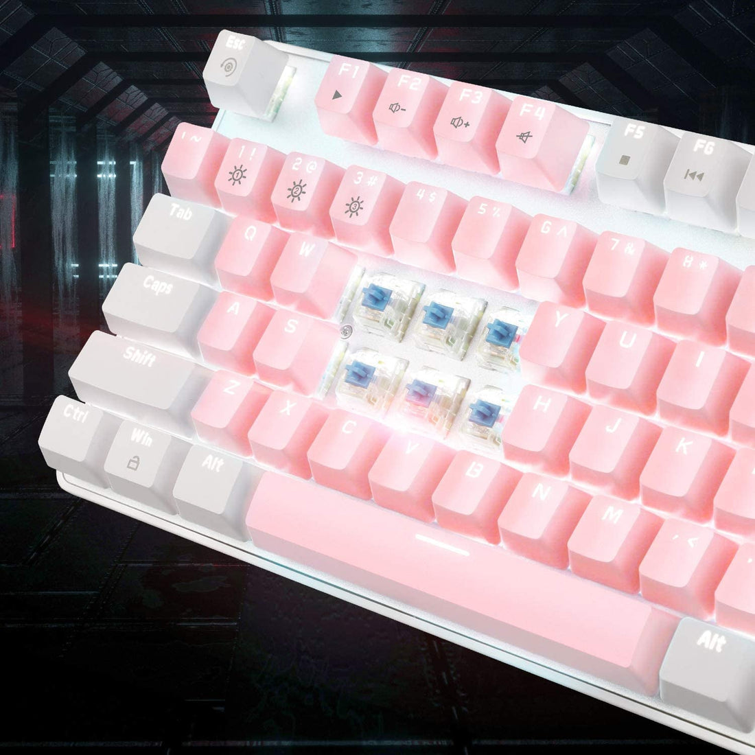 White and pink mechanical keyboard with keycaps removed to expose blue switches underneath