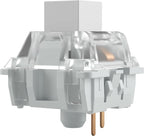 Side profile of a white mechanical keyboard switch with clear top housing and gold PCB pins visible underneath