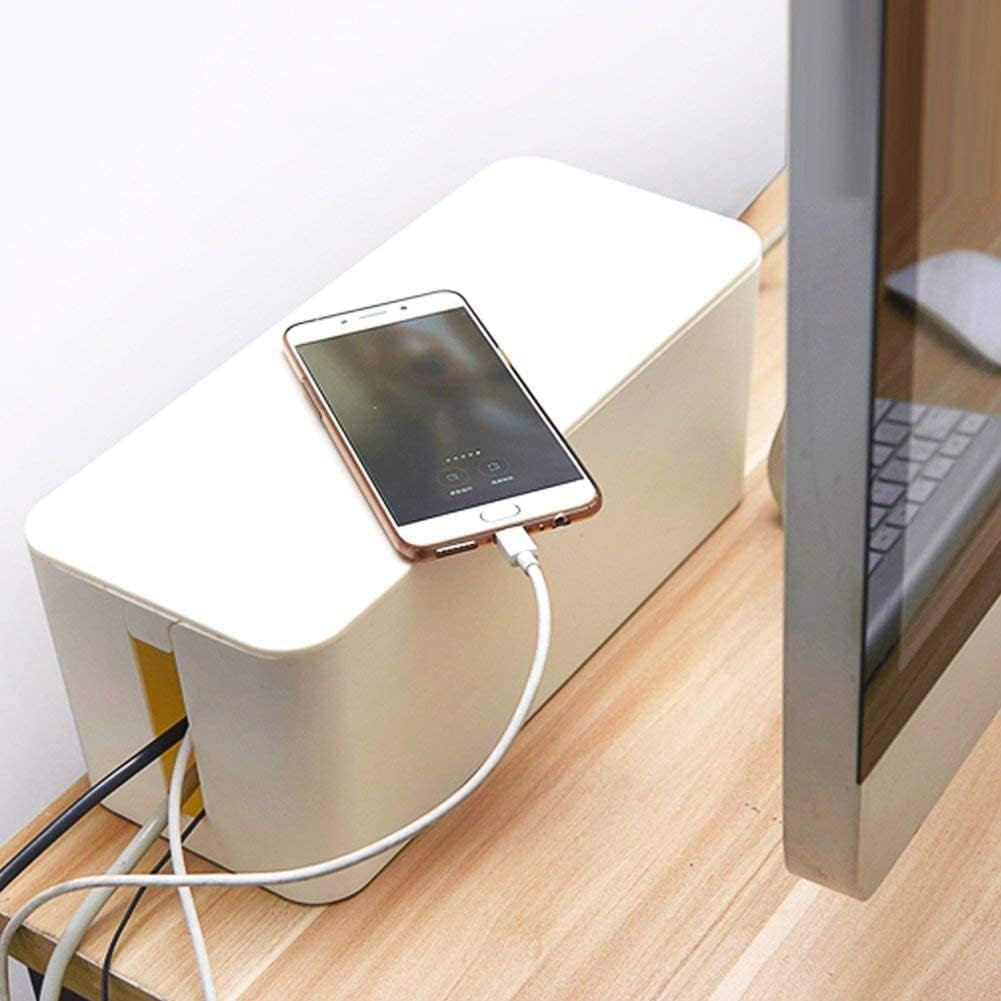 Cable management box on wooden table organizing USB-C cable that is charging a smartphone