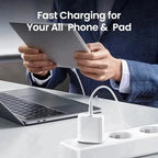 White 30W USB-C wall charger plugged into a white multi-outlet power strip on a white desk, connected via white USB-C cable to a silver tablet held by a man in a navy suit jacket, with silver MacBook Pro open on the desk beside the power strip, and bold white text reading Fast Charging for Your All Phone and Pad