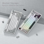 Two mechanical keyboards side by side showing Womier creamy keycaps installed, one with RGB backlight shining through the legends