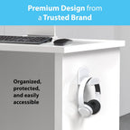 White over-ear headphones hanging on a TotalMount white wall mount hanger adhered to the right side panel of a white standing desk, with a dark wired keyboard and black wireless mouse visible on the desk surface above, with light blue banner reading Premium Design from a Trusted Brand and text reading Organized, protected, and easily accessible