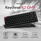 Keychron K2 QMK Version 3 mechanical keyboard angled on a grey surface with palm leaf shadow, showing red Escape keycap and RGB backlighting, with four feature icons below: Launcher Web Configurator, Enhanced Acoustic Foams, 2.4GHz and Bluetooth 5.2, Support macOS and Win