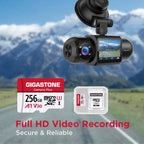 Gigastone 256GB Camera Plus microSD card and SD adapter with dash cam mounted on a car windshield against a mountain road backdrop