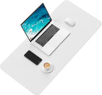 Laptop, smartphone, mouse, and coffee cup on a white desk mat with a white background