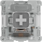 Top-down view of a mechanical keyboard switch showing white cross stem inside clear housing with internal spring and contact leaf visible