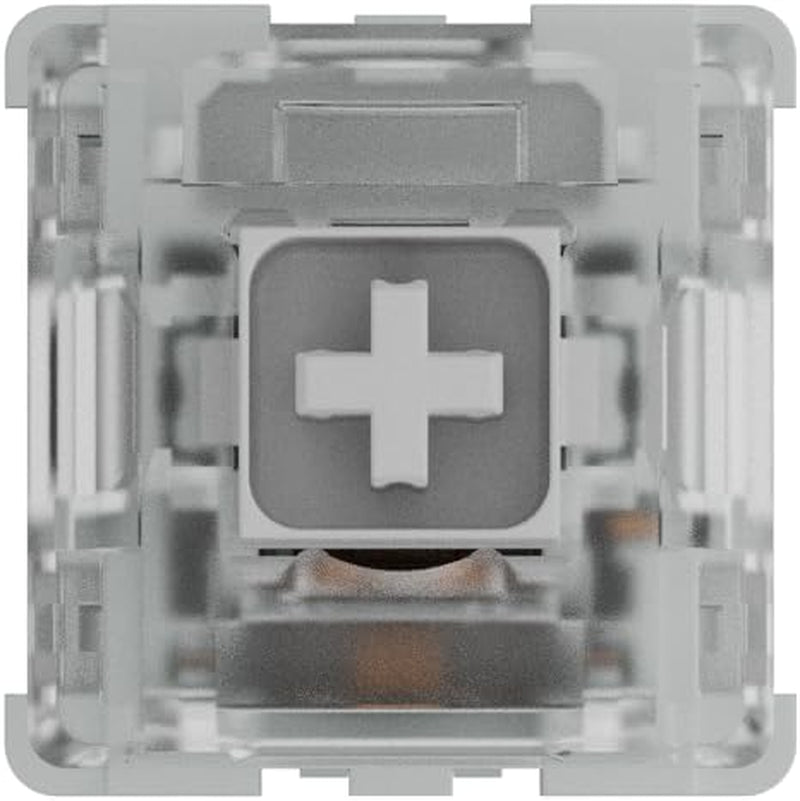 Top-down view of a mechanical keyboard switch showing white cross stem inside clear housing with internal spring and contact leaf visible