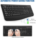 Black ergonomic wireless keyboard shown from above on a white background with bold blue text reading "Automatic Power Saving Function" at the top, two callout labels showing a blue sleep moon icon reading "30min Auto-enter sleep" and a green battery icon reading "15 Months" battery life, and a lower inset image showing two hands typing on the keyboard with blue circles highlighting the home row keys and caption reading "Press any key to active"