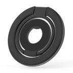 Double-sided magnetic phone grip and kickstand in matte black showing circular double-ring design with rotating inner ring, folded flat on white background