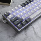 Redragon K617 Fizz 60% Grey and White Mechanical Gaming Keyboard with left-angled USB-C Cable and blue RGB lighting on marble desk